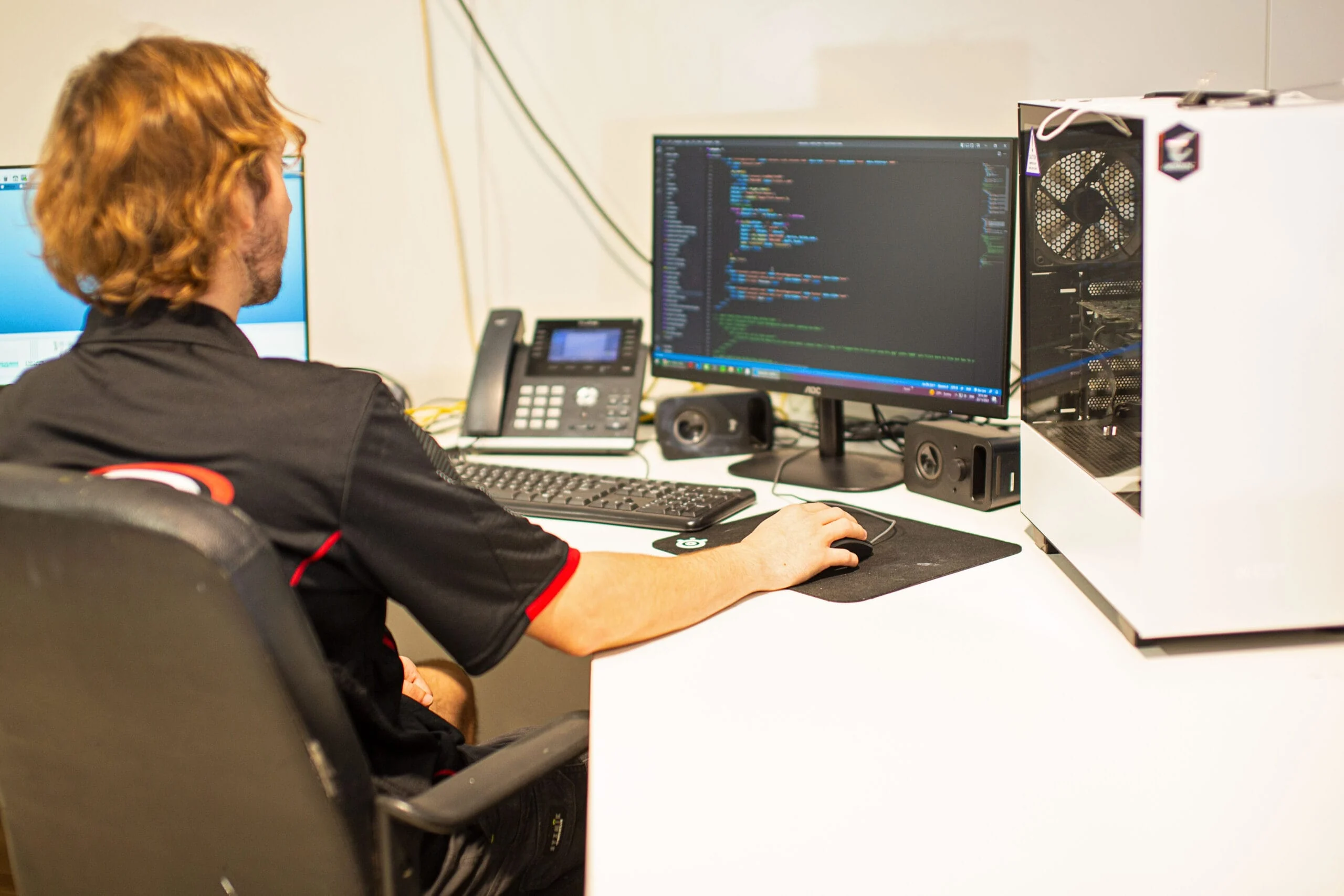 Web developer coding a client website at a workstation