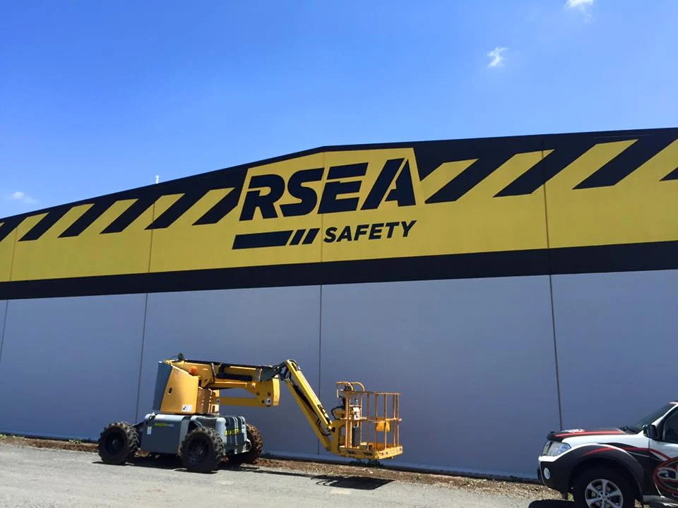 ALE crew installing RSEA Safety fascia signage from an elevated work platform