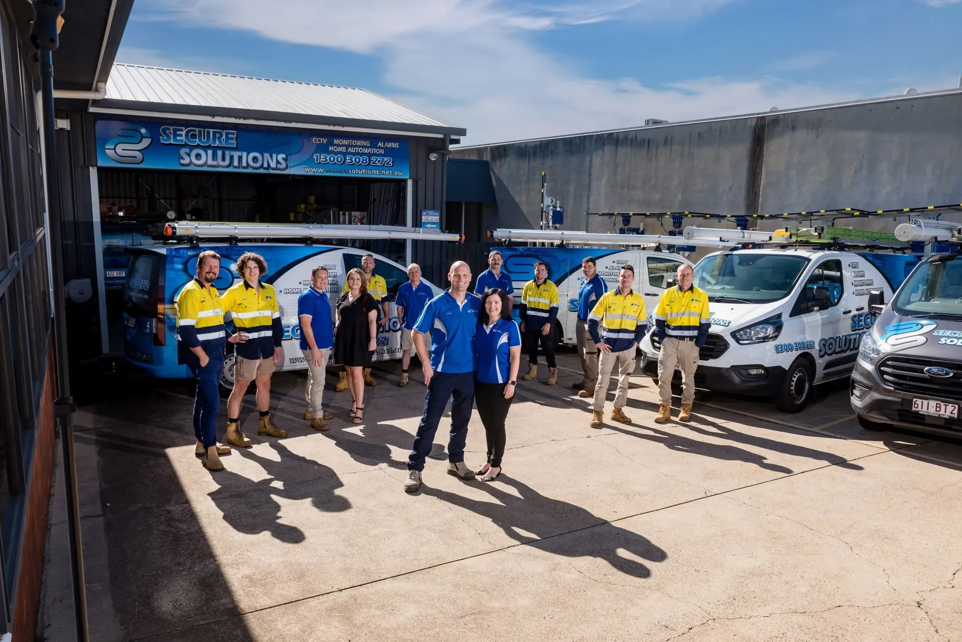 Secure Solutions team standing with their wrapped fleet