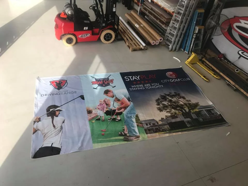 Large banner print laid out on the workshop floor