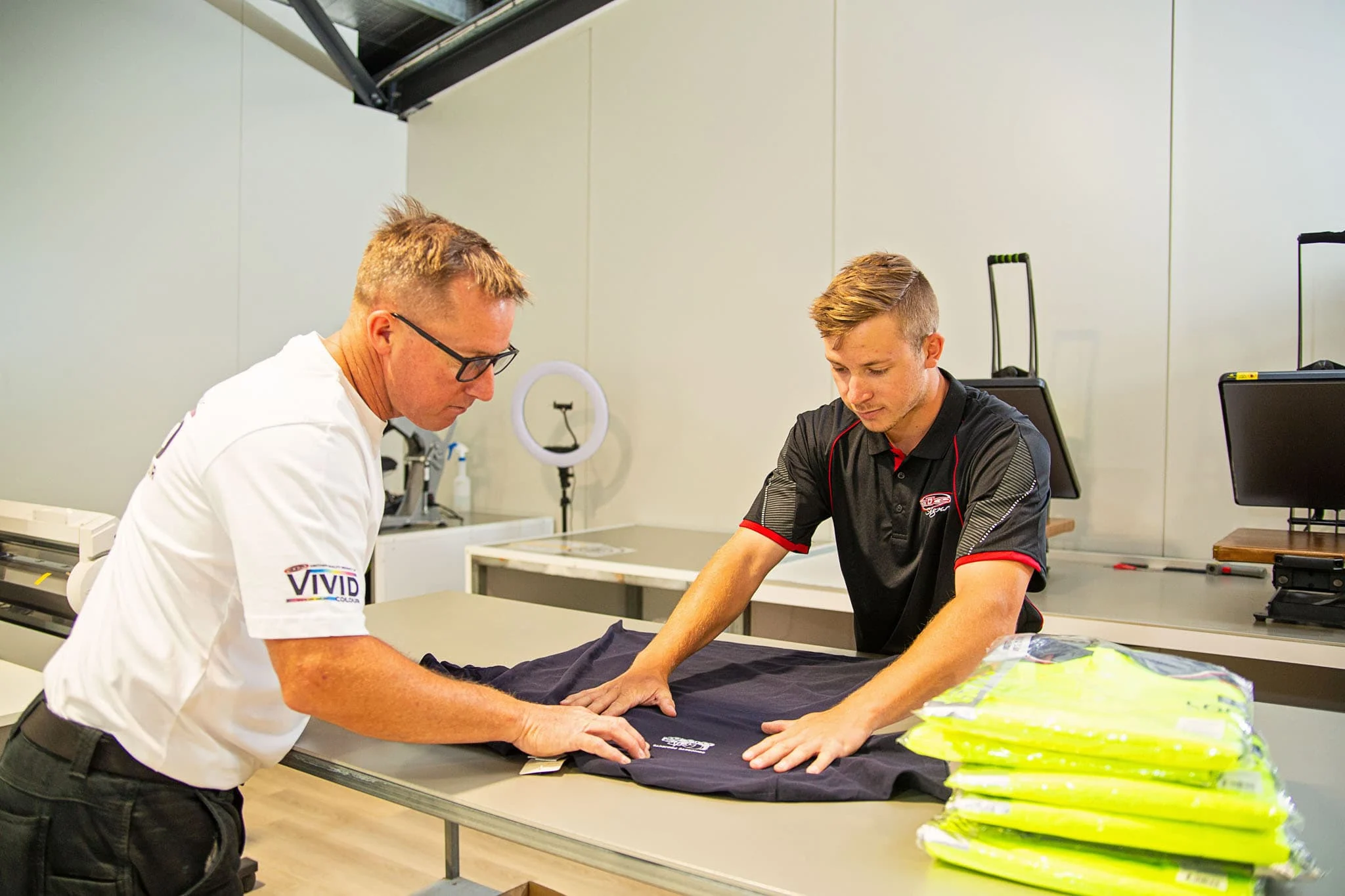 Two ALE staff folding branded uniforms in the Toowoomba clothing workshop