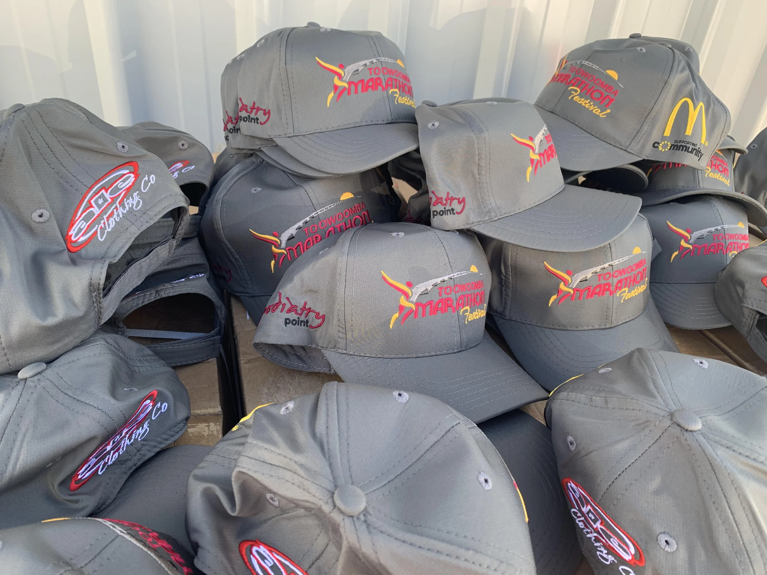 Embroidered Toowoomba Marathon Festival caps with sponsor logos on the sides