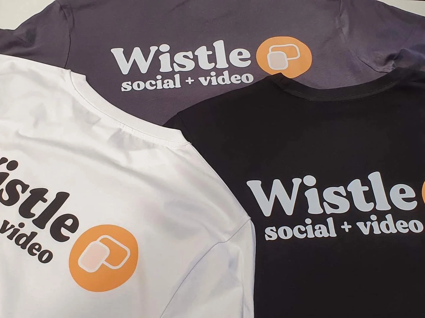 Wistle social + video logo printed on black and white tees