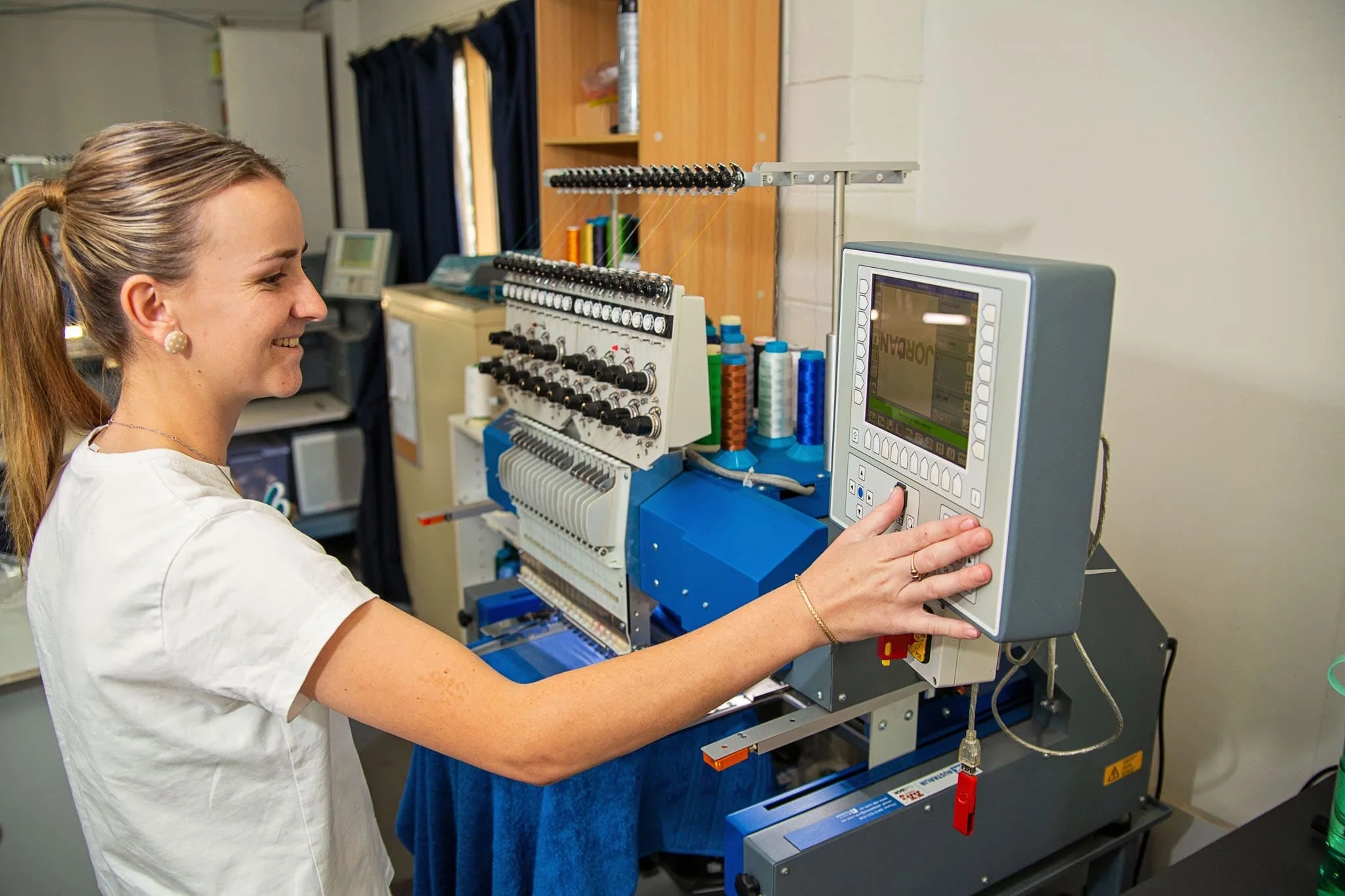 ALE team member setting up a multi-head embroidery run